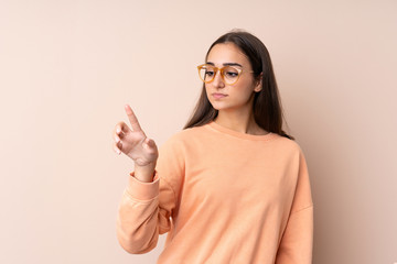 Young girl over isolated background touching on transparent screen