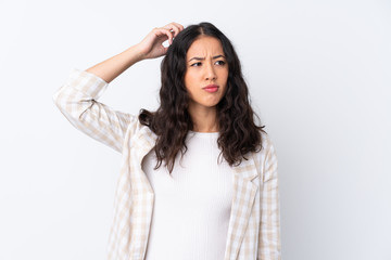 Fototapeta premium Mixed race woman over isolated white background having doubts while scratching head
