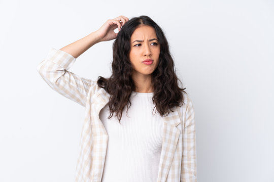 Mixed race woman over isolated white background having doubts while scratching head
