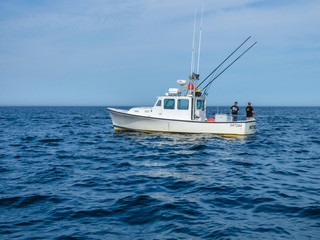 Fototapeta premium Couple fishing off a boat on the blue Atlantic Ocean off Cape Cod