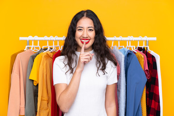 Mixed race woman in a clothing store doing silence gesture