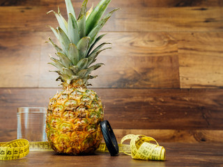 Diet weight loss fitness health care concept with measure tape, pineapple, water glass, fitness...