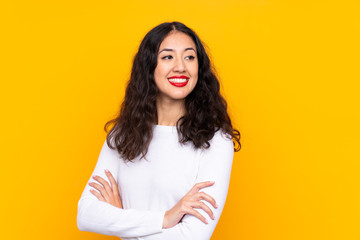 Mixed race woman over isolated yellow background laughing