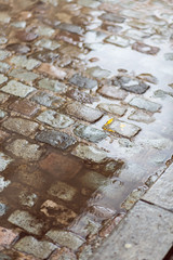 Water rain puddle on an old cobble stone street