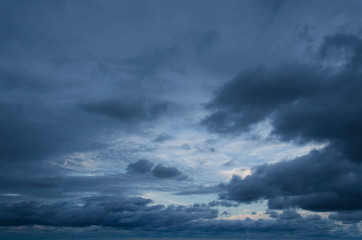 Fototapeta na wymiar Cloudscape: a small clear blue part of the sky and dark gray stormy clouds