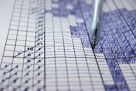 Close up pen on a sheet with a solved Japanese Crossword. Leisure activities