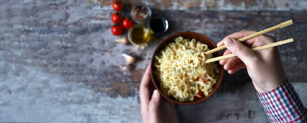 Man eating noodles with chopsticks. Chinese noodles.