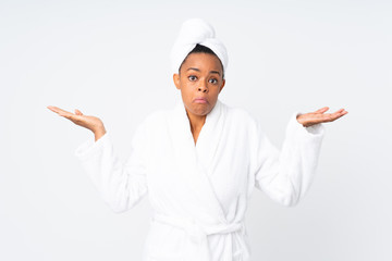 African american woman  in a bathrobe over isolated background having doubts with confuse face expression