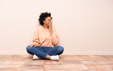 African american woman sitting on the floor smiling a lot