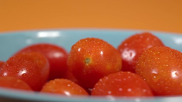 Concept of genuine and fresh tomato. Chery tomatoes on a wooden board revolve in a circle.