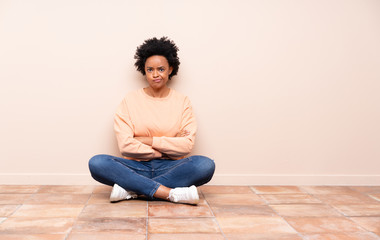 African american woman sitting on the floor feeling upset