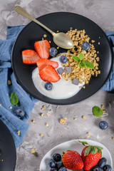 Ripe blueberries and strawberries with yogurt and granola