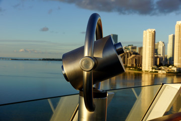 a telescope of a cruise ship, in the background skyscrapers of the Miami skyline