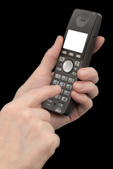 Female hand holds a phone with a white blank screen, isolated on black background