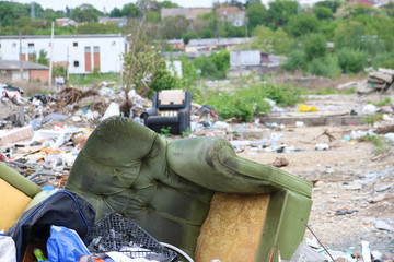 Damaged green armchair on debrise