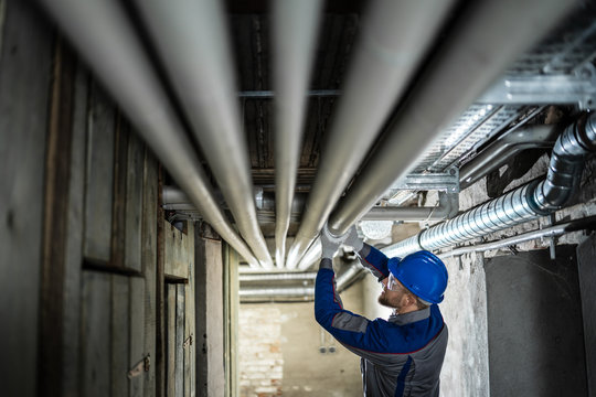 Male Worker Inspecting Pipes