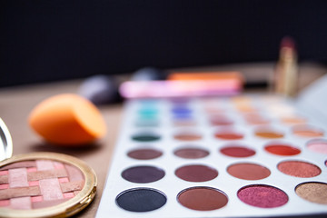 Makeup studio with all the accessories such as shadow palettes, concealers, makeups, eyeliners, brushes, lipstick and highlighter