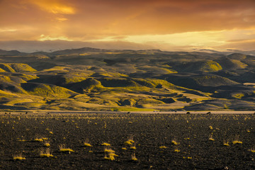 Dramatical scene of sunset with big mountain for background and empty land space with small bush at Vik, Iceland. Beautiful green layer on the mountain. Idea for any backgrounds use.