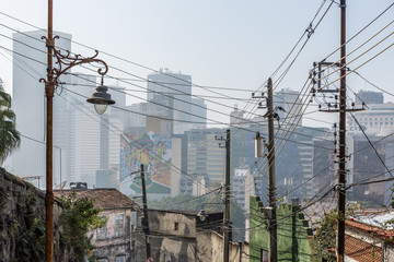 View from Lapa neighbourhood looking towards high rise buildings & offices in Rio with electricity cables & street lamps in foreground in Brazil, South America