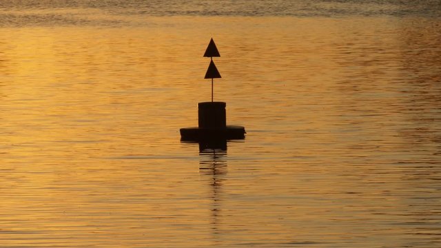 Nautical buoy sign on the Lujan river at sunset.
