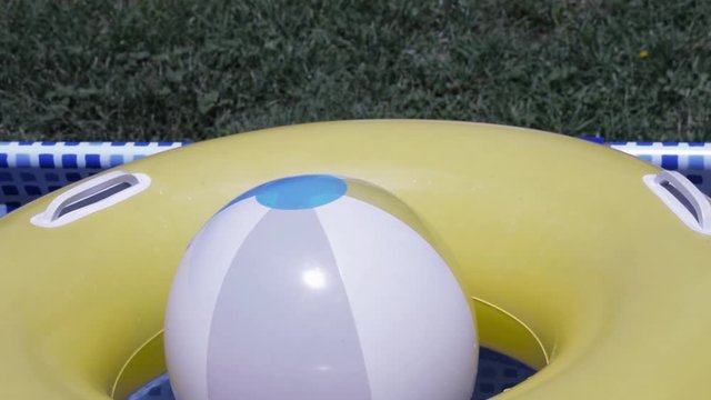 Pelota y aro inflable en piscina