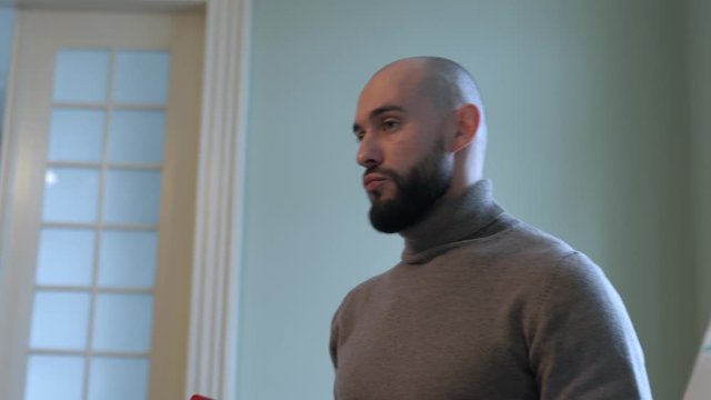 Handsome bald man with beard making speech, 4K