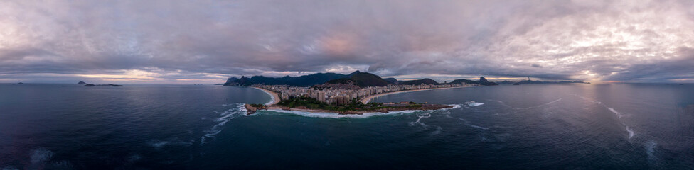 Rio de Janeiro, Brazil, with Arpoador rock and Copacabana fort in the foreground and wider cityscape in the background against an overcast slightly coloured sunrise sky. Aerial 360 degree panorama