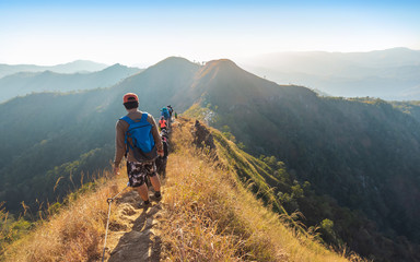 Fototapeta premium beautiful landscape with trekkers walking on mountain ridge in sunset at Thong Pha Phum National Park Kanchanaburi of Thailand