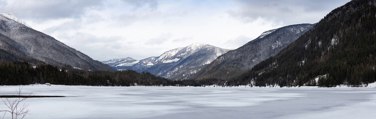 Fototapeta na wymiar Three Valley Lake, near Revelstoke, British Columbia, Canada. Beautiful panoramic Canadian Landscape View of Frozen water and mountains in winter.