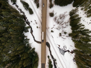 Aerial View from Above of a Highway crossing the river and Railway tracks during winter. Taken in...