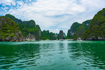 Fototapeta na wymiar Lime stone formations and blue sea at Ha Long bay, Vietnam.