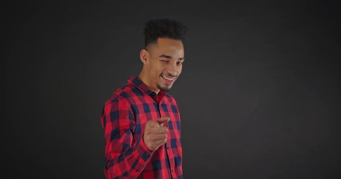 Beautiful african man in shirt flirting on dark background