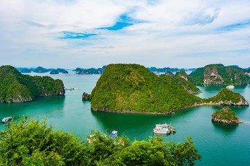 Fototapeta na wymiar Aerial view of Ha Long Bay; with a lot of limestone islets and cruise ships; on a cloudy summer day.