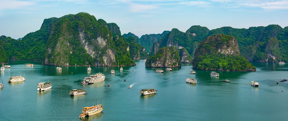 Aerial view of Ha Long Bay; with a lot of limestone islets and cruise ships; on a cloudy summer day.
