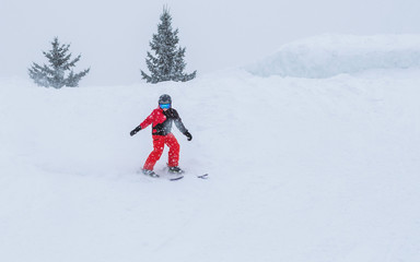 People are having fun in downhill skiing and snowboarding in the middle of snowfall 