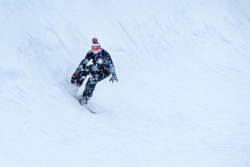 Fototapeta na wymiar People are having fun in downhill skiing and snowboarding in the middle of snowfall 