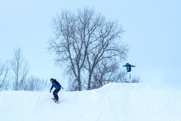 People are having fun in downhill skiing and snowboarding in the middle of snowfall 