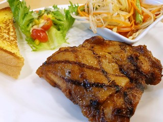 Selective focus of grilled chicken steak with sauce and vegetable salad on white plate, Ready to eat
