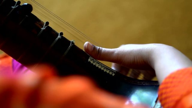 Close up view of hands on the Sitar instrument. A professional player performing with the ancient Indian musical instrument.