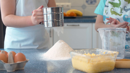 Hands of kids cooking cakes