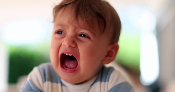 Cute baby complaining crying out loud wanting attention. Toddler yelling opening mouth