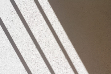 Fototapeta premium The white and gray plaster walls are rough, White and gray-white plaster surfaces, The shadow of the window on the floor of the white room in the morning.