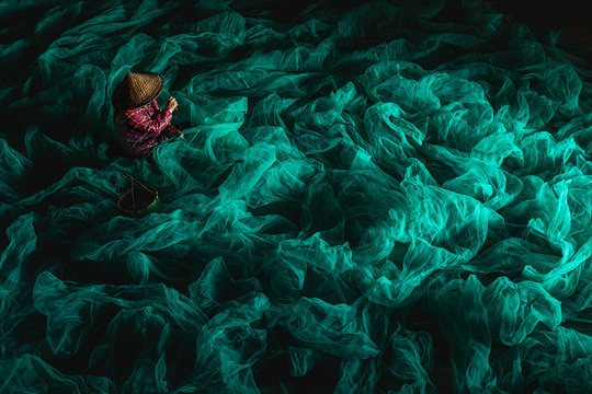 A fisherman who mends his net indoors