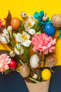 A bouquet of bright spring flowers and colorful easter eggs. View from above. Top view. Happy Easter, springtime concepts