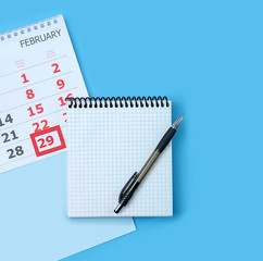 Calendar with marking in red pin of 29 february date. February month, calendar, notebook, pen. leap day in leap year concept.