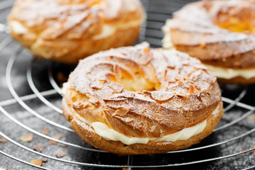 Obraz na płótnie Canvas Homemade choux pastry cake Paris Brest with almond flakes and sugar powder.