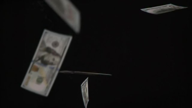 Money Rain. Loop. Monetary denominations of $ 100 in a large number of slowly falling down on black background. Filmed at a speed of 240fps