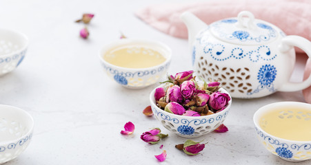 Fototapeta na wymiar Herbal tea with roses on light gray background.