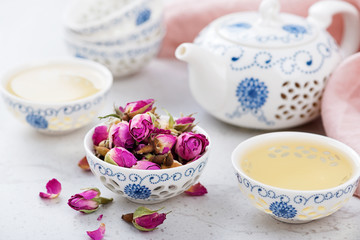 Herbal tea with roses on light gray background.