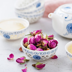 Herbal tea with roses on light gray background.